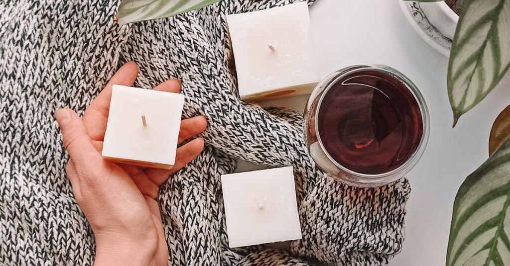 Warm candlelit setting with wine and leaves, perfect for a relaxing autumn evening.