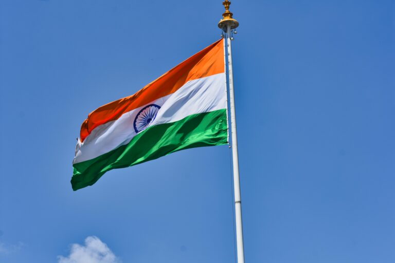 The Indian national flag waving against a clear blue sky symbolizes patriotism and national pride.