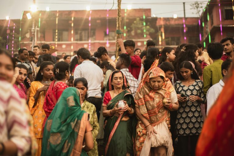 Vibrant crowd celebration at an Indian festival, showcasing traditional clothing and festive lights.